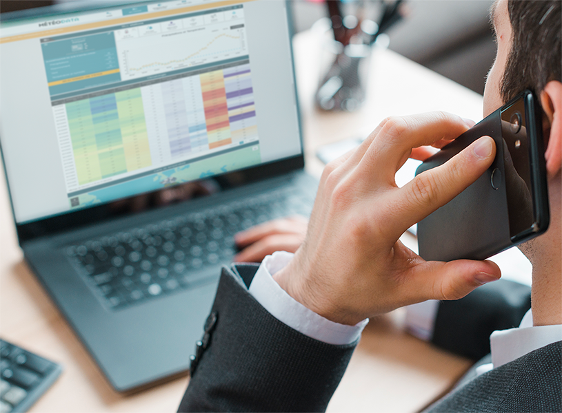 Un homme est au téléphone tout en consultant l'interface Météodata